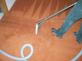Ein Mitarbeiter der Teppichreingung Karsten Vorwerk Berlin bei einer Teppichbodenreinigung im privaten Haushalt. Hier wird eine Sprühextraktion ausgeführt.